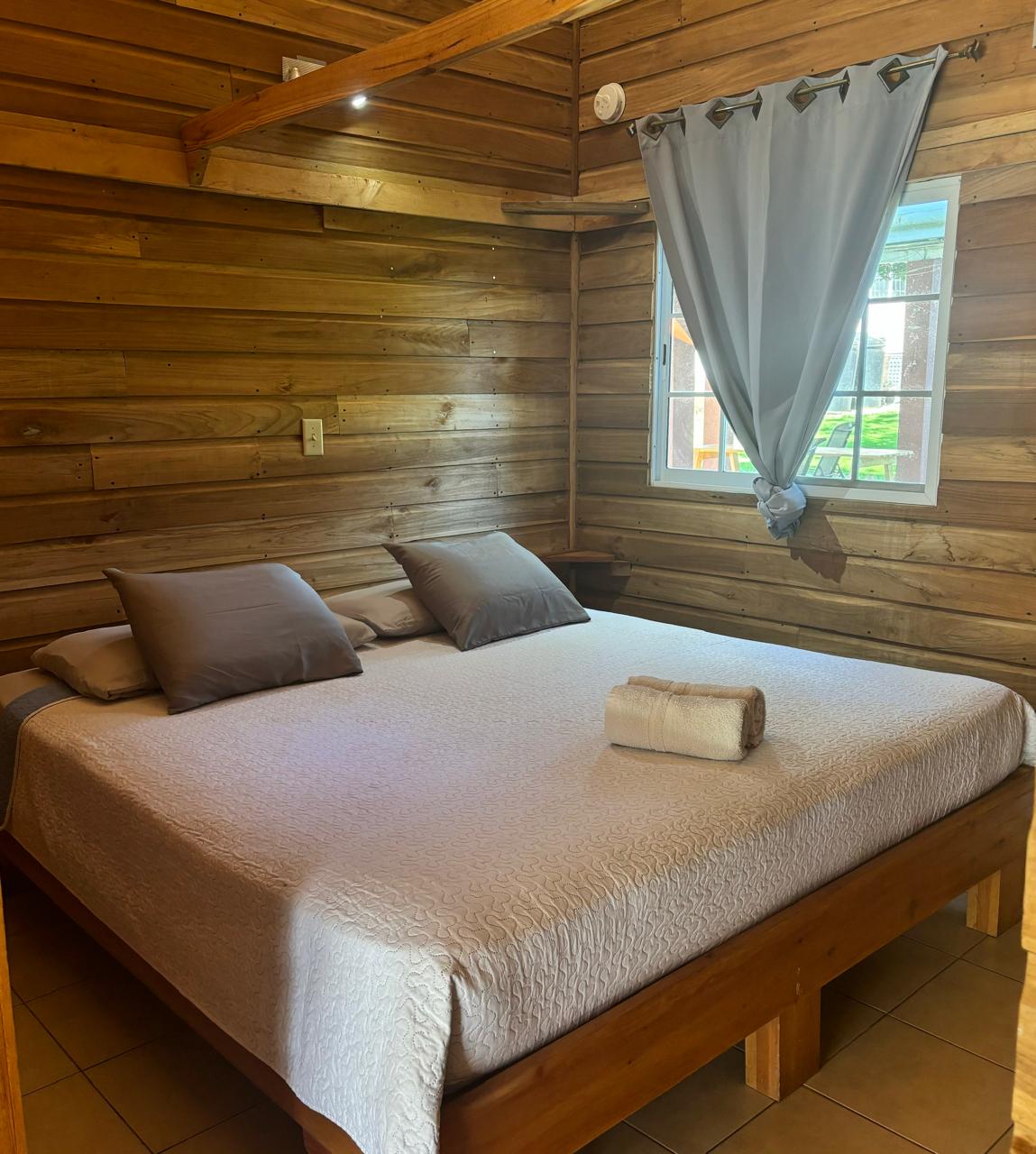 Chambre en bois d'une cabane familiale avec grand lit